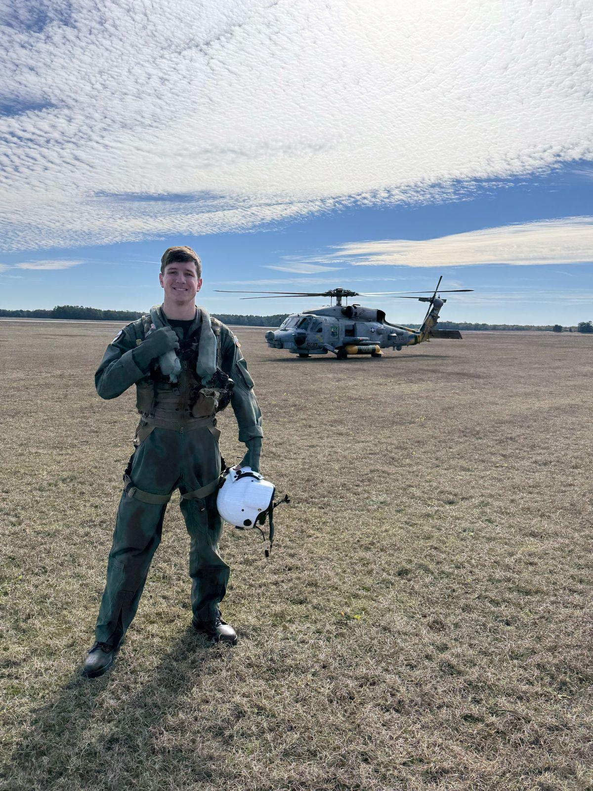 Naval aviation student standing on the flight line at NAS Whiting Field with a TH-73 Thrasher helicopter in the background